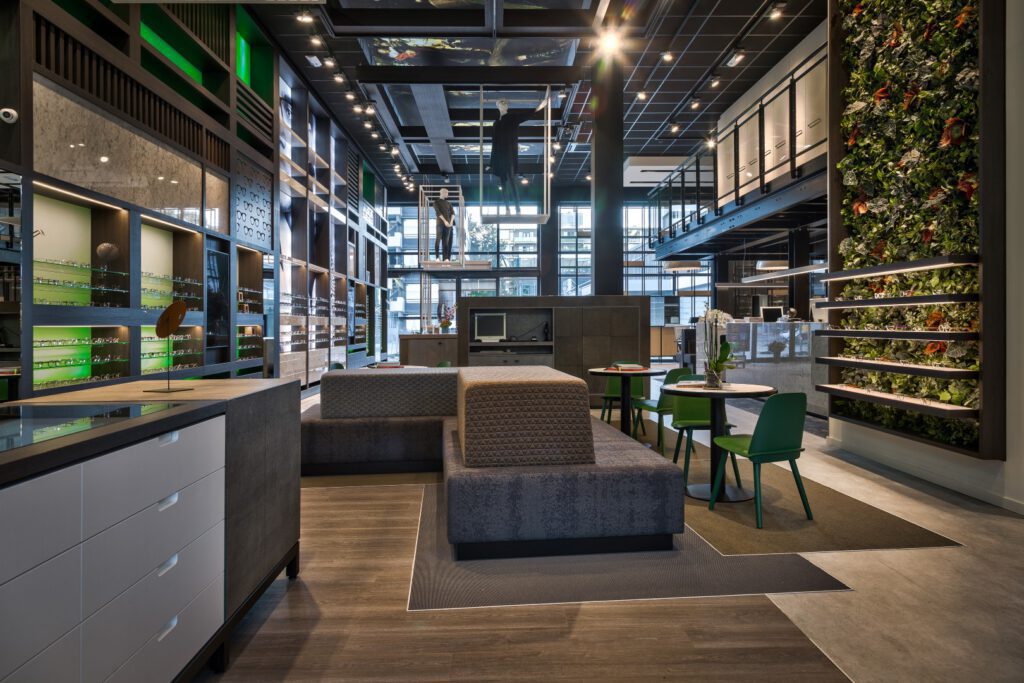 magasin d'optique design d'intérieur avec vitrines et présentoirs muraux aux accents verts et bois