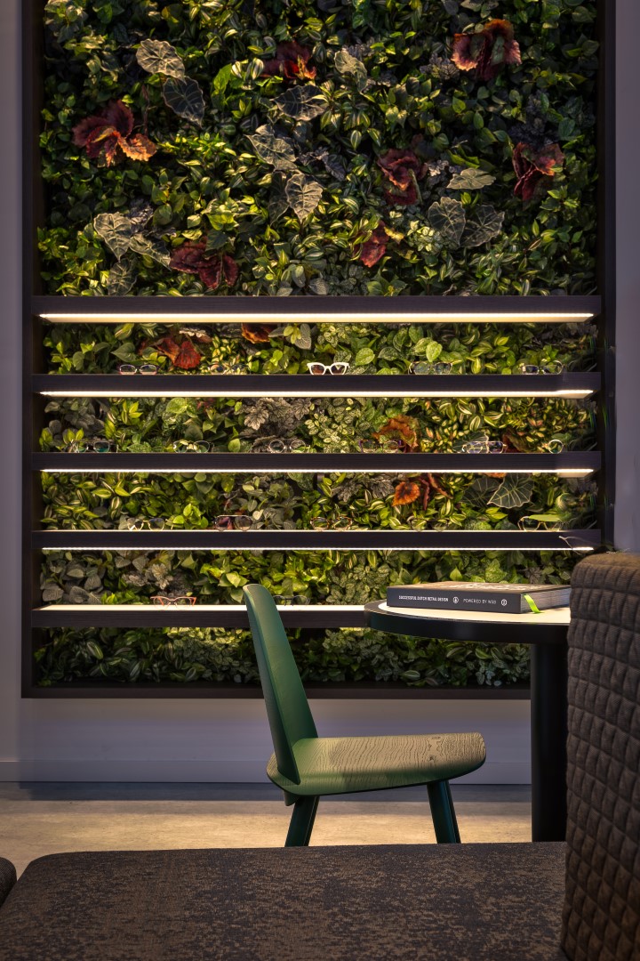 Detail of the wall display case with light band and natural wall in shop interior design