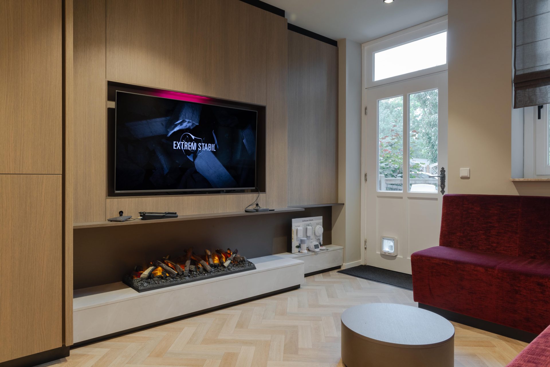 Espace de test auditif près de la télévision et de la cheminée dans un aménagement moderne d’audioprothésiste